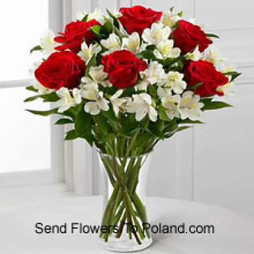 Sette rose rosse con fiori bianchi assortiti e riempitivi in un vaso di vetro
